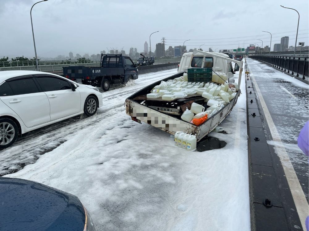 新北市下雪? 華江橋事故大量泡沫奇觀 2 《圖說》小貨車上載運的洗潔劑、漂白水與沙拉脫等清潔用品掉落橋面,造成大量泡沫擴散,影響行車安全。〈海山分局提供〉