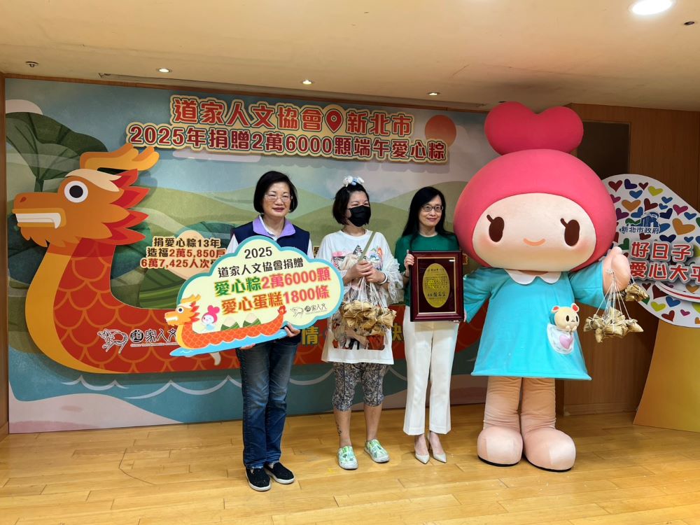 道家人文協會捐愛心粽 連續13年22萬顆 3 《圖說》道家人文協會理事長張旖代表捐贈愛心粽,與新北社會局長李美珍一同將粽子給予受贈代表小錡〈中〉。〈記者葉柏成攝〉