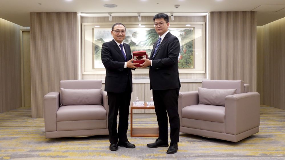 強化青年合作共創永續未來 青年商會中華民國總會拜會侯友宜 4 《圖說》青商會第73屆總會長蔡政諺(圖右)回贈由陶藝大師李仁燿製作的開運杯。〈青年局提供〉