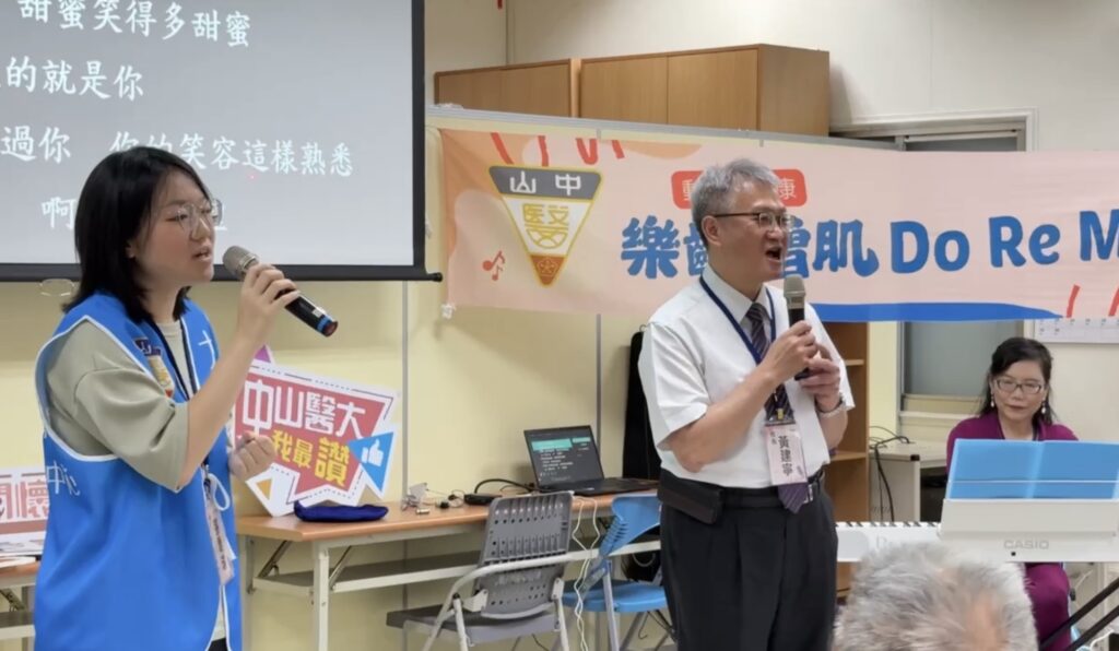 03 中山醫大校長黃建寧右與學生志工運用喉部肌力訓練方式，領唱「甜蜜蜜」。