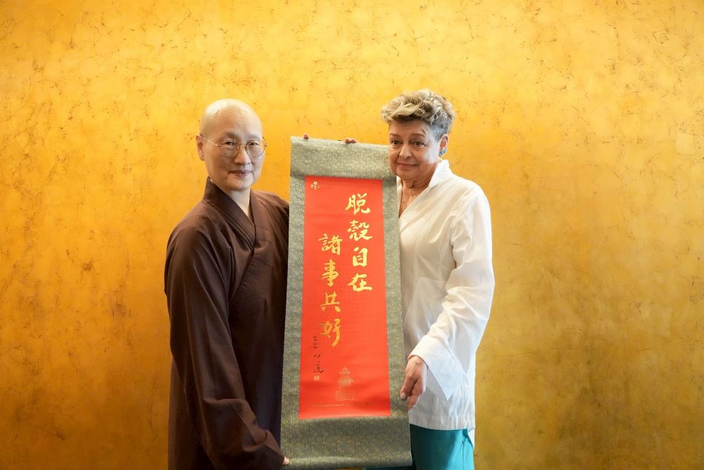 參訪宗博館 瓜地馬拉第一夫人感受光與信仰交會 1 《圖說》世界宗教博物館發展基金會執行長顯月法師(左)致贈創辦人心道法師「脫殼自在,諸事共好」卷軸給瓜地馬拉第一夫人貝娜多。〈宗博館提供〉