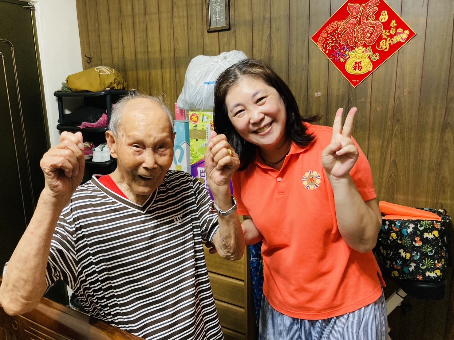 〈慶福〉愛心不打烊 攜手新北榮服處清涼「衣」夏 11 《圖說》百歲榮民方爺爺(左)開心試穿涼感衣,尺寸合身,臉上洋溢著滿足笑容,吳曉慧總幹事(右)陪同在側,場面溫馨。〈新北榮服處提供〉