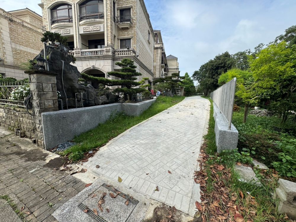 打造慢活綠空間 林口住宅區綠地活化添一樁! 2 《圖說》林口區泰林路三段與仁愛路一段間的L型空地遭圍設占用,市府團隊合作排除占用,重新規劃為綠色步道,近日已完工開放使用。圖為完工前。〈工務局提供〉