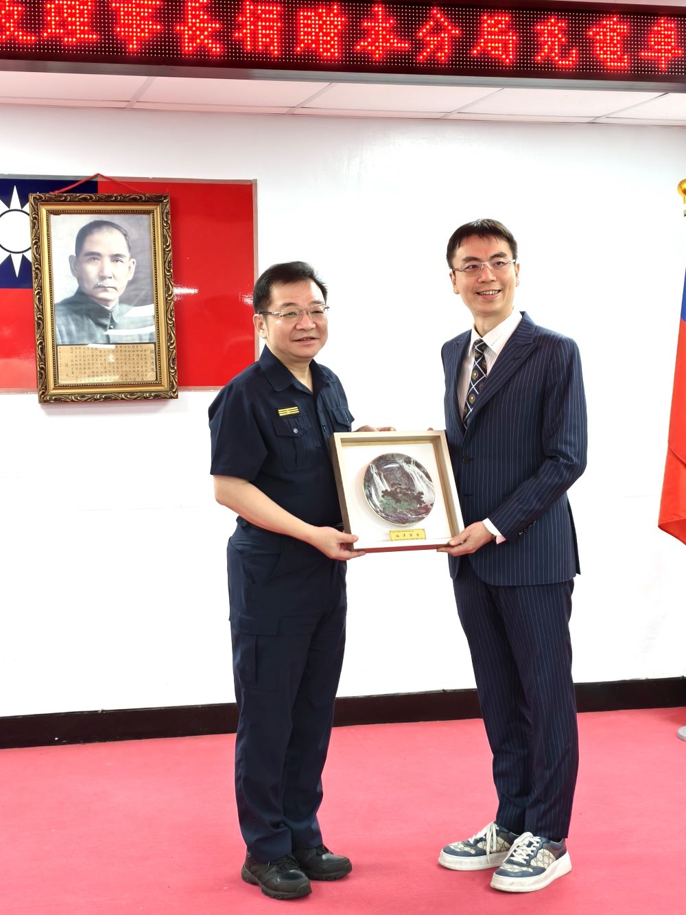 感謝警察同仁奉獻 溫世政贈永和警車頂警示燈 2 《圖說》分局長王耀輝回贈嚴屏觀瀑寫盤掛飾。〈永和分局提供〉