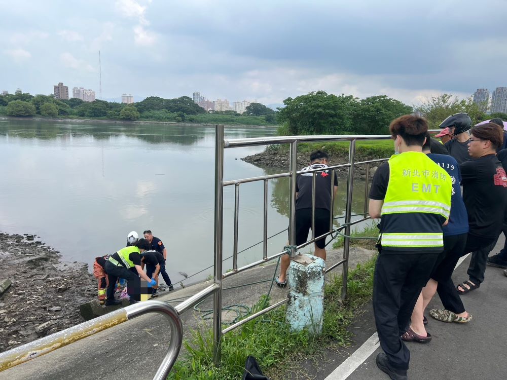 家庭不睦落水漂浮 警消不顧泥濘救援近百歲嫗 4 《圖說》海山警消合力救起漂浮於岸邊老婦。〈海山分局提供〉