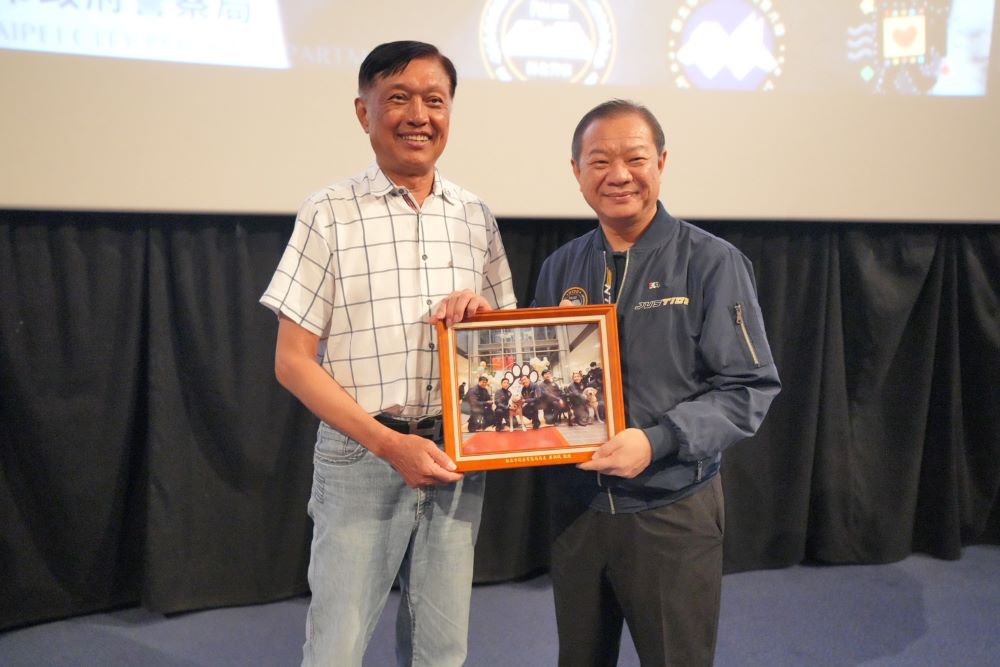慶祝警察節獻禮 新北《八歲K9》首映會慰勞同仁 2 《圖說》廖訓誠局長致贈警犬海報予新北市警察之友會理事長黃志彰。〈警察局提供〉