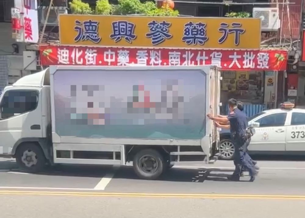烈日力推拋錨貨車 警專實習生上了寶貴一課 2 《圖說》三重員警烈日當空冒著毒辣的太陽協助將拋錨重達5噸的貨車推往路邊,以便即早恢復交通順暢。〈三重分局提供〉