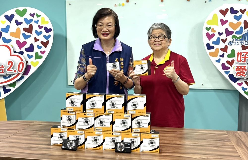 新北記者工會媒合 世界佛正心會捐贈「小衛星」數位相機 2 《圖說》社會局長李美珍、佛教正心會執行長陳和慧與致贈的數位相機合影。〈記者葉柏成攝〉